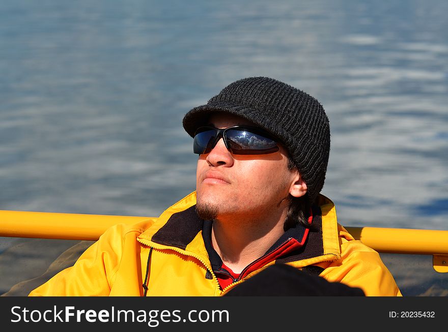 Young man in sunglasses relaxing on boat. Young man in sunglasses relaxing on boat