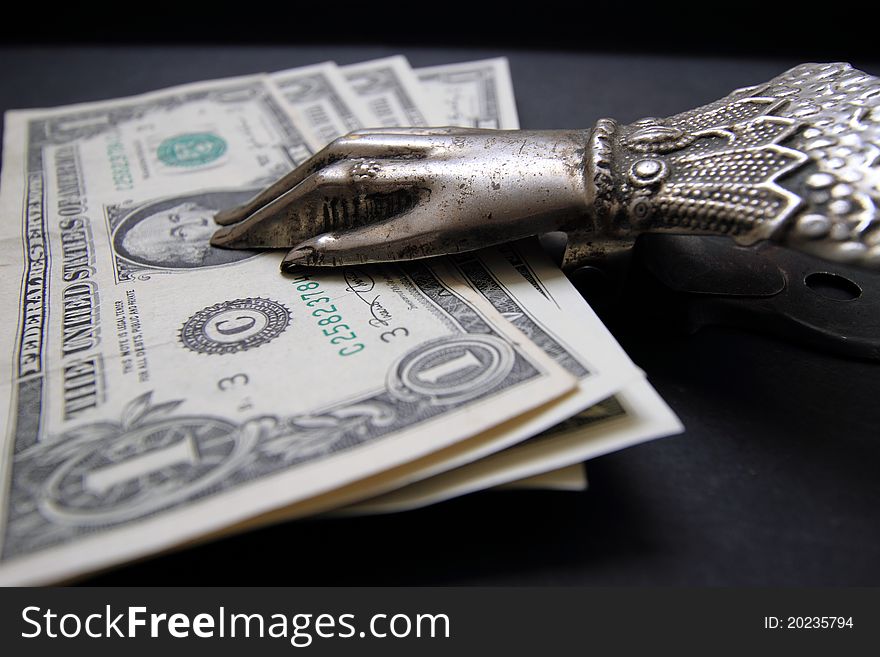Dollars in a clothespin-holder, against a dark background