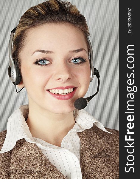 Woman with telephone headset against the gray background