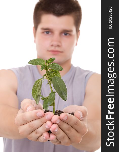 A young man holding a plant in hands
