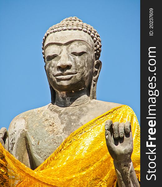 Stone old buddha image in a temple with blue sky. Stone old buddha image in a temple with blue sky