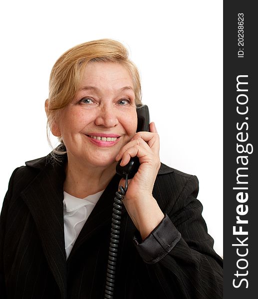 Senior Woman talking on the phone in black suite on white background. Blond hair. Shot in studio.