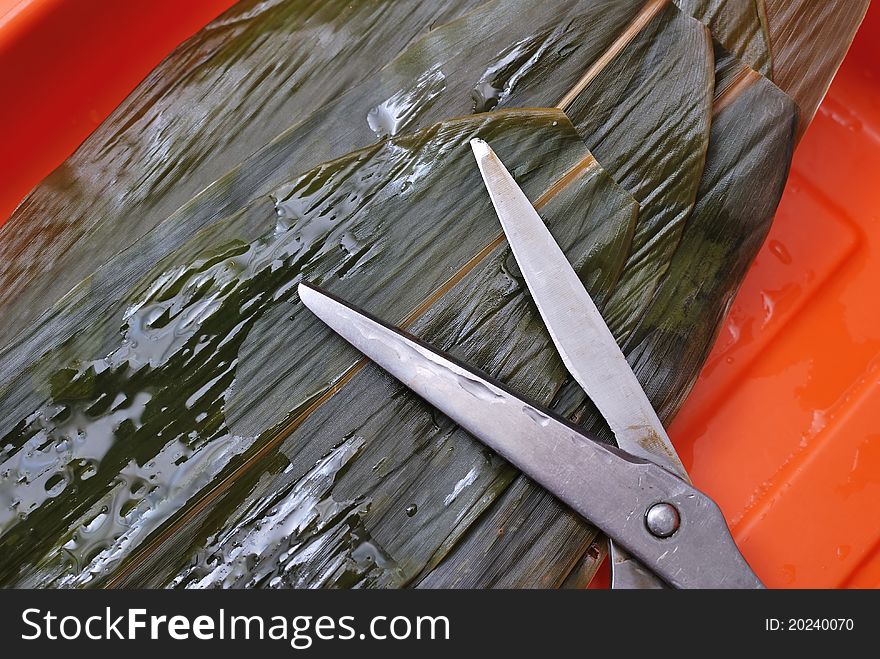 Large bamboo leaves washed clean and trimmed for wrapping dumplings. Large bamboo leaves washed clean and trimmed for wrapping dumplings.