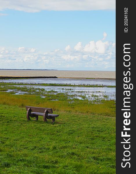 Bench with view onto the tidal flats at the north sea. Bench with view onto the tidal flats at the north sea
