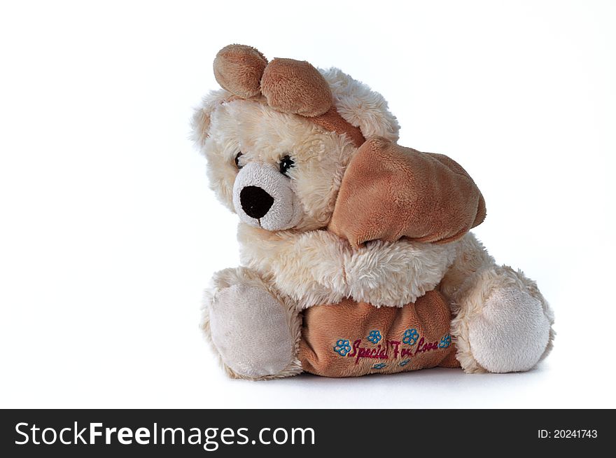 Cheerfull brown teddy bear hugging a pillow