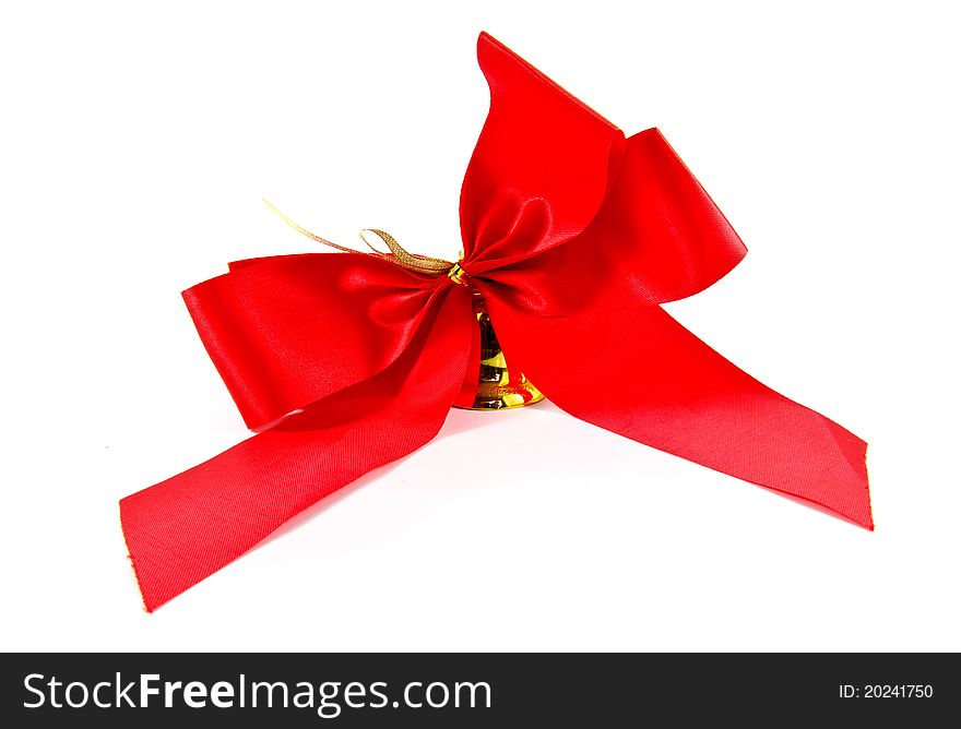 Ribbon golden bell with red satin bow isolated on white