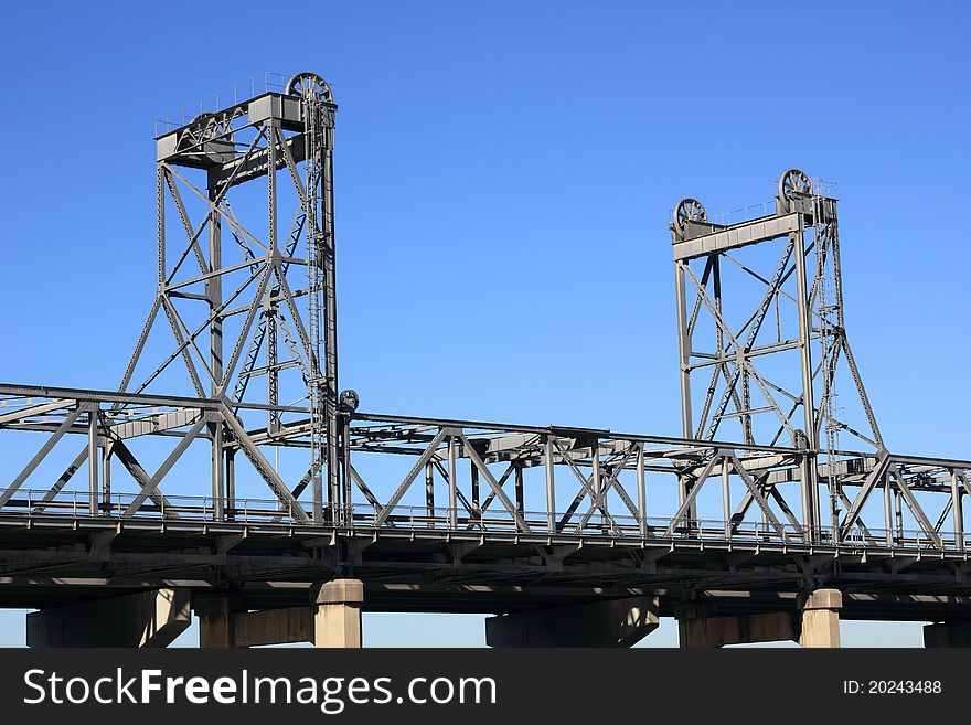 Detail of a vertical-lift bridge (drawbridge) - set against blue sky