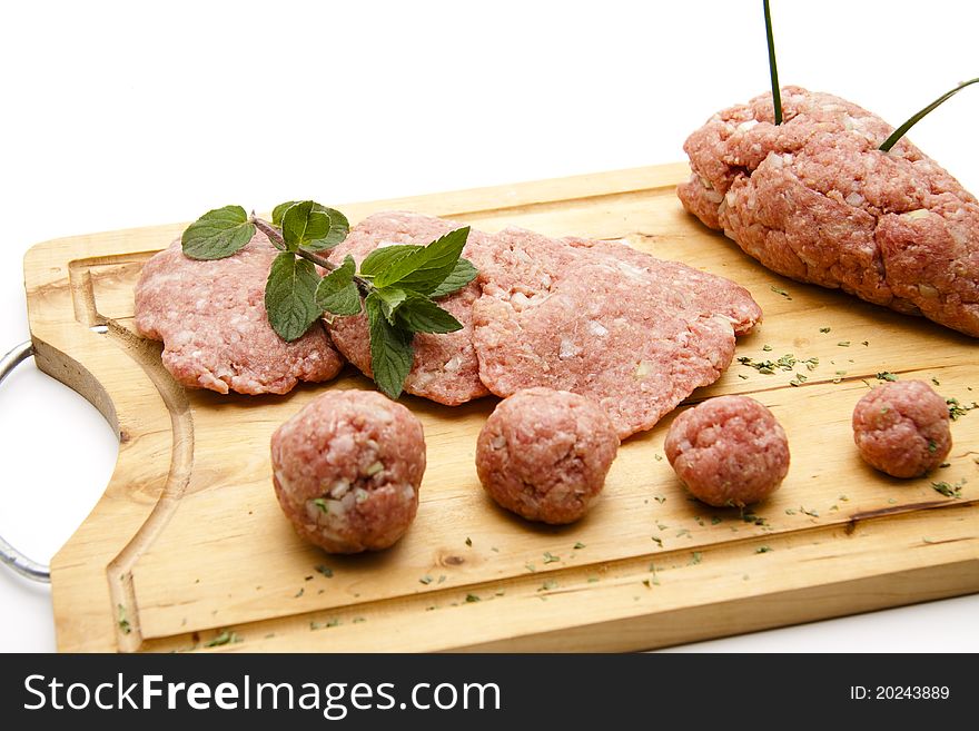 Raw mincemeat and herbs on edge board