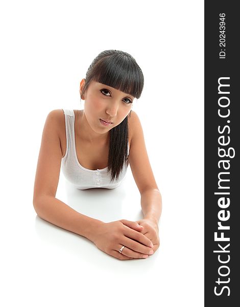 A young mixed race woman girl relaxing on the floor and looking directly at camera. White background with space for copy. A young mixed race woman girl relaxing on the floor and looking directly at camera. White background with space for copy.