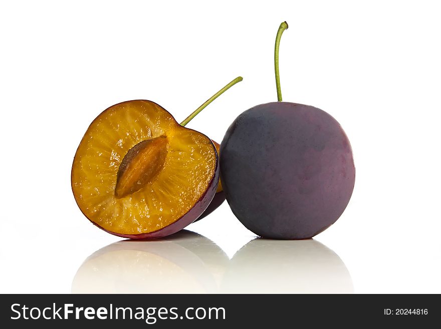 Bunch of plums or damsons fresh from the tree with one sliced. Bunch of plums or damsons fresh from the tree with one sliced