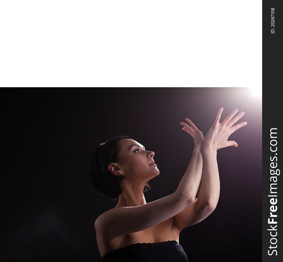 Young beauty woman in dark look at light with yoga sign. Young beauty woman in dark look at light with yoga sign