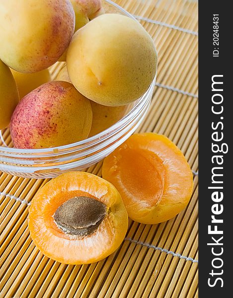 Ripe apricots in plate on table