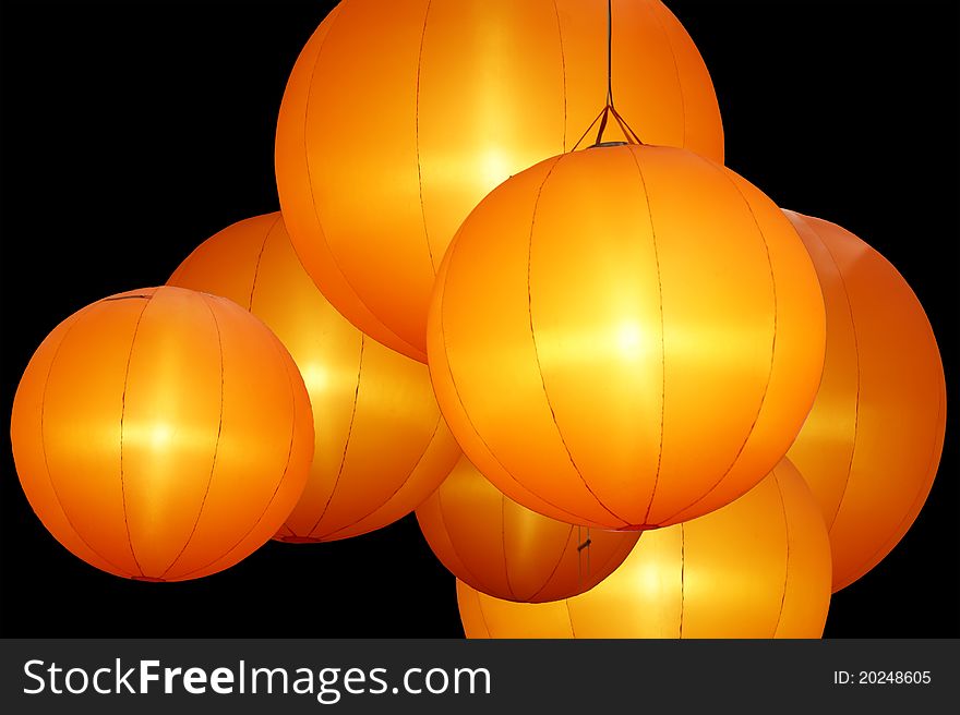 Warmly colored balloon lamps isolated on black background