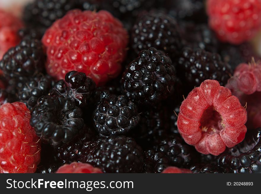 Pile of blackberries and raspberries closeup. Pile of blackberries and raspberries closeup