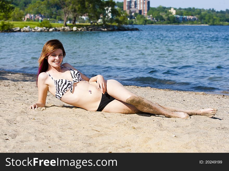 A young sexy girl covered in sand at the beach in a bathing suit. A young sexy girl covered in sand at the beach in a bathing suit.