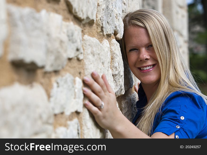 A beautiful young female leans against a wall. A beautiful young female leans against a wall