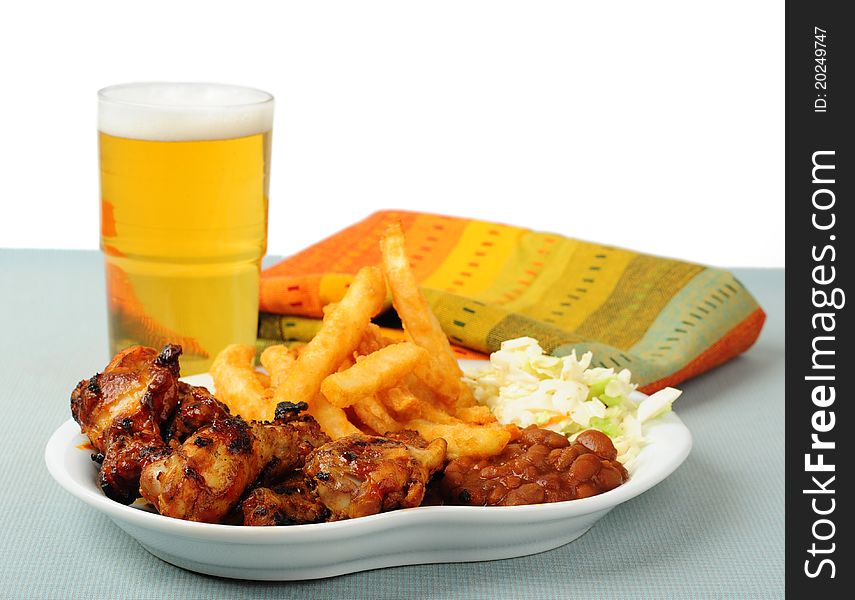 Plate of delicious barbecued chicken wings with beer. Plate of delicious barbecued chicken wings with beer.