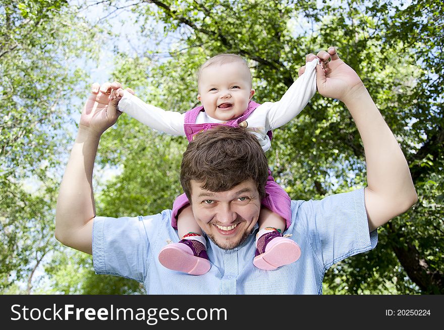 Father playing with baby, baby sitting on father. Father playing with baby, baby sitting on father