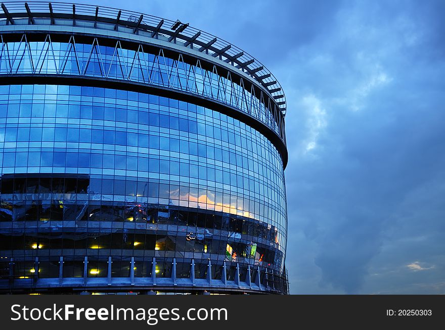 Barrel-like office building with city lights reflections