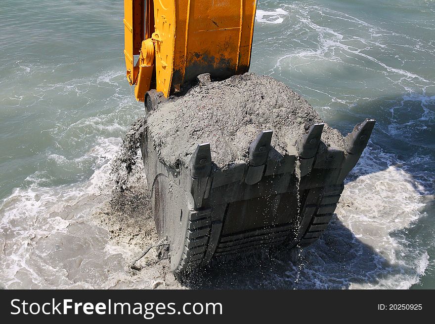 Excavator bucket of water from the soil of the seabed