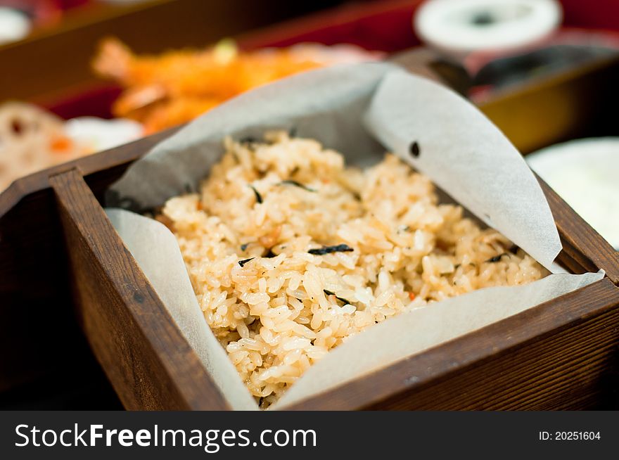 A traditional Japanese rice set meal for lunch with seaweed garnish, tempura prawn and lotus root side dish. A traditional Japanese rice set meal for lunch with seaweed garnish, tempura prawn and lotus root side dish.