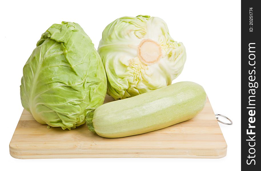 Fresh vegetables on wooden chopping board isolated over white background