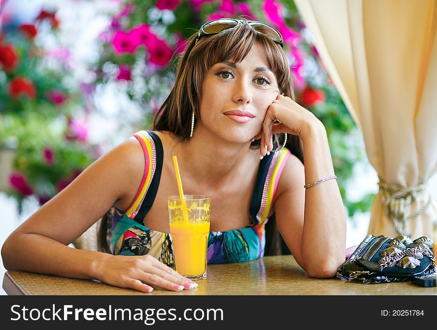 Woman Drinking Orange Juice In Cafe