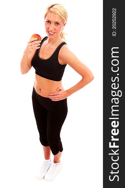 A young female dressed in black exercise clothes eating an apple