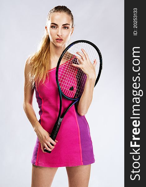 Beautiful model with tennis racket, studio portrait