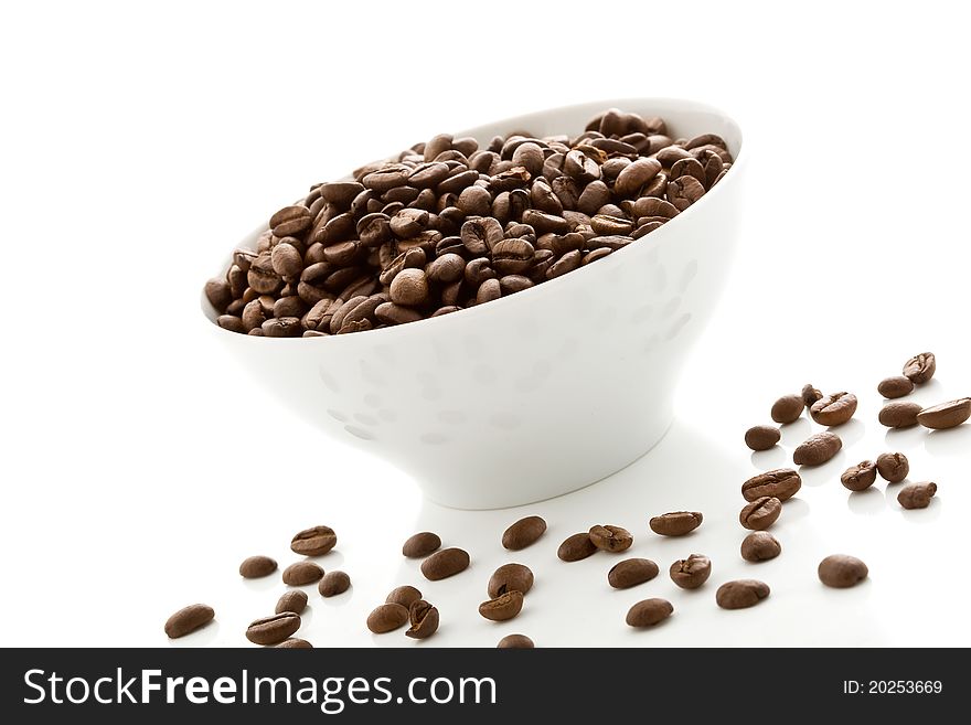 Photo of delicious coffee beans inside a white bowl on white isolated background