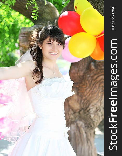 Beautiful Bride with colorful balloons the air