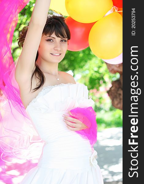 Beautiful Bride with colorful balloons the air