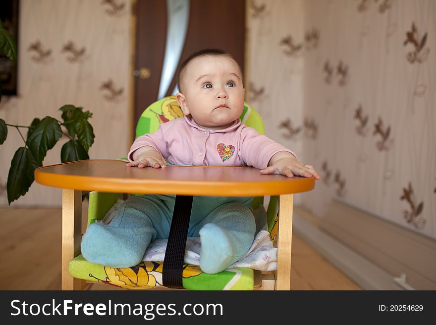 Little girl child sitting at a table and children's laughter