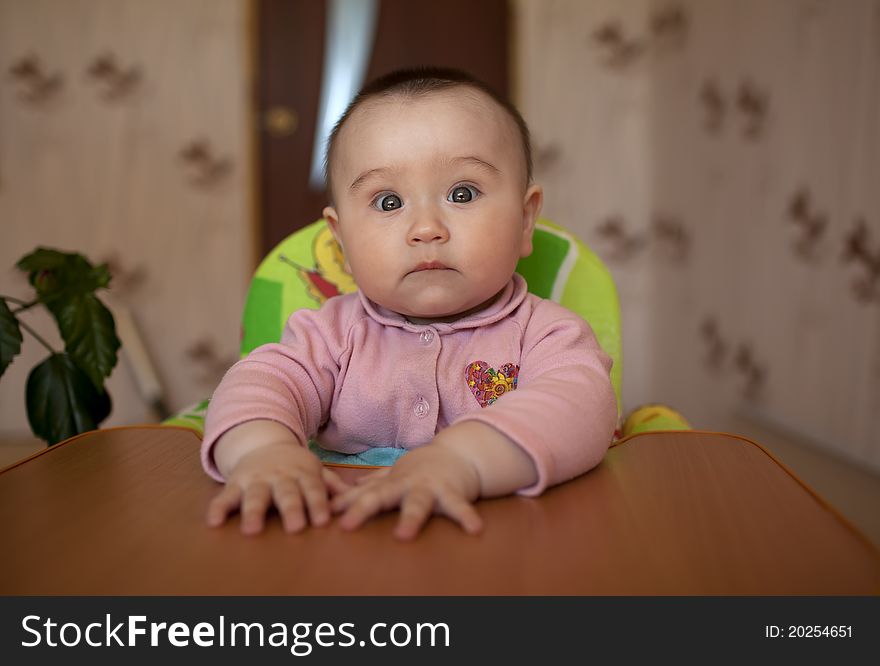 Little girl child sitting at a table and children's laughter