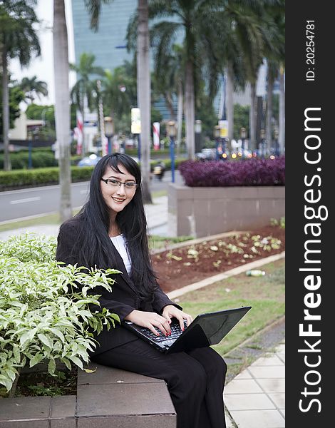 Businesswoman working outdoor on her laptop