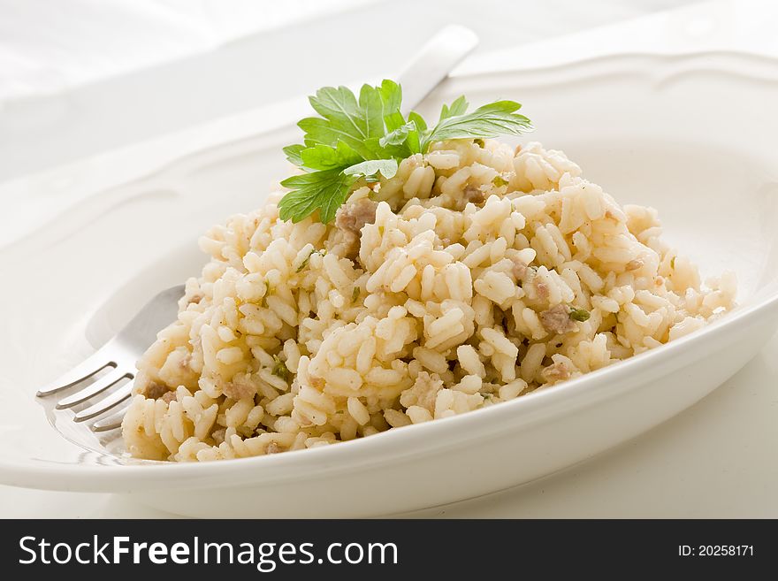 Photo of delicious italian risotto dish with meat and parsley on white isolated background. Photo of delicious italian risotto dish with meat and parsley on white isolated background