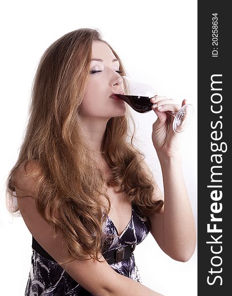 Girl with long hair sitting on a white background and drinking wine. Girl with long hair sitting on a white background and drinking wine