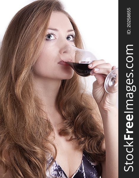 Girl with long hair sitting on a white background and drinking wine. Girl with long hair sitting on a white background and drinking wine