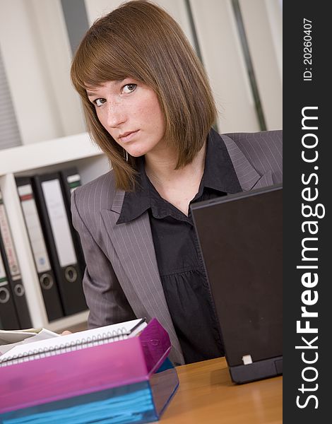 Young woman by office work with laptop