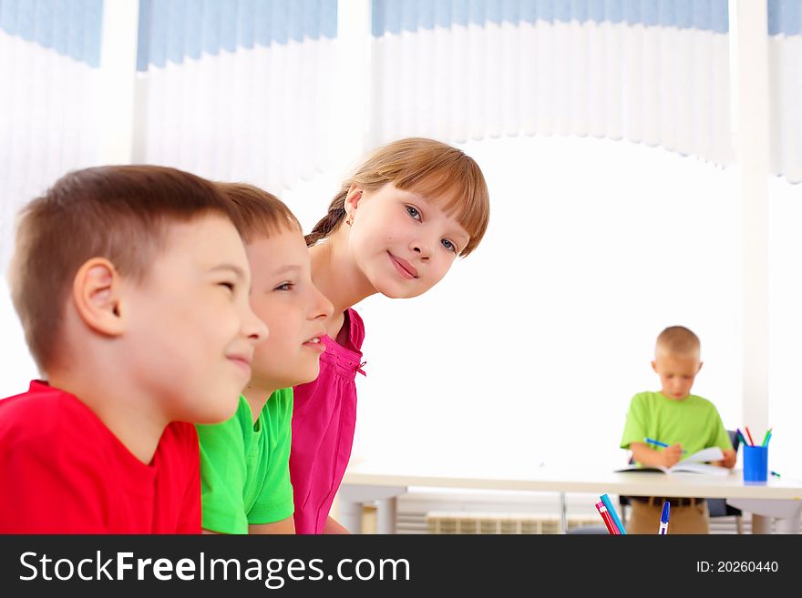 Group classmates standing in a row in the classroom