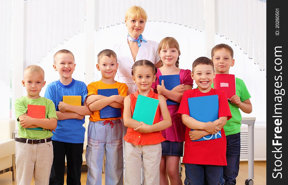 Group classmates standing in a row in the classroom