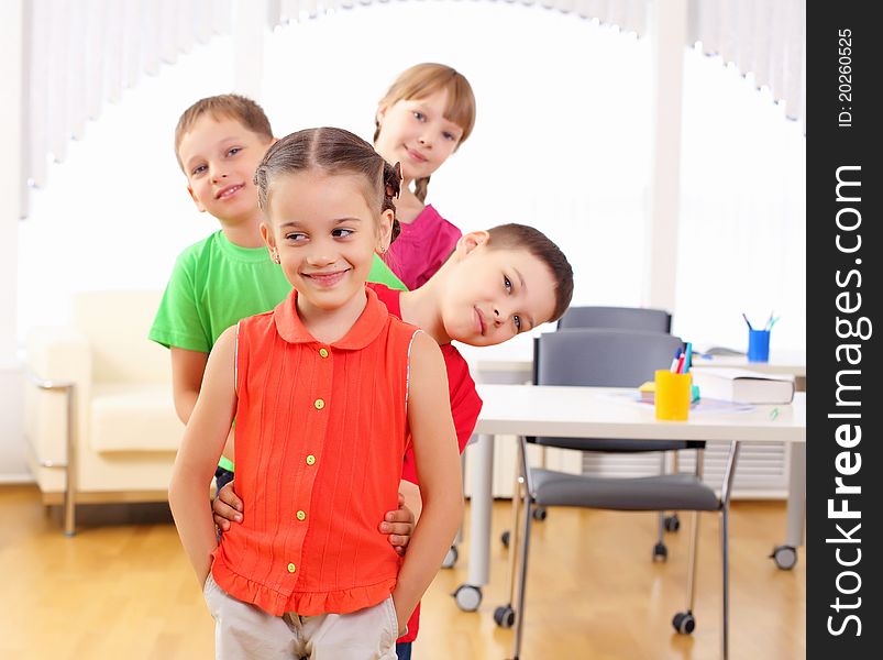 Group classmates standing in a row in the classroom