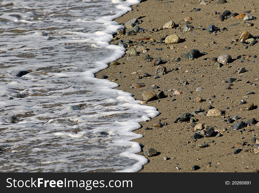 Water froth on the sandy beach