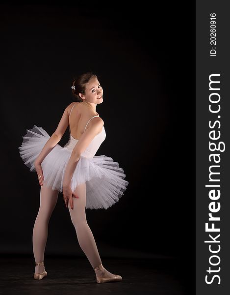 Ballerina in a white skirt and a bathing suit, pointe, dance poses