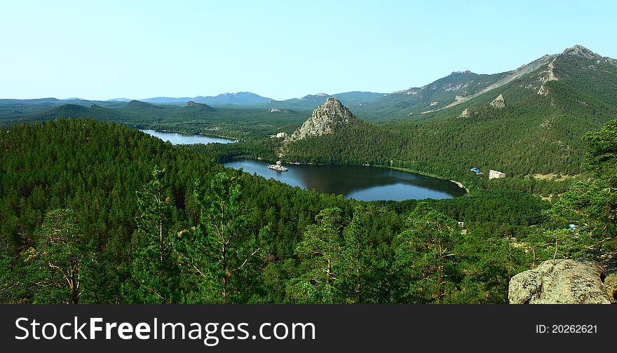 Bright summer landscape depicting a lake Borovoe and rocks; covered with coniferous forest. Bright summer landscape depicting a lake Borovoe and rocks; covered with coniferous forest