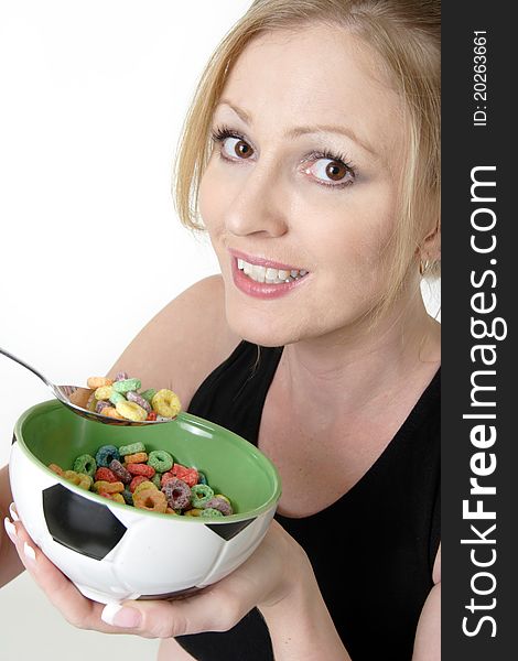 Attractive blond caucasian woman enjoying a bowl of colorful cereal with a happy expression. Attractive blond caucasian woman enjoying a bowl of colorful cereal with a happy expression