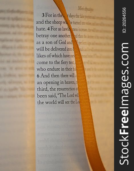 A religious book with an orange ribbon marker. A religious book with an orange ribbon marker