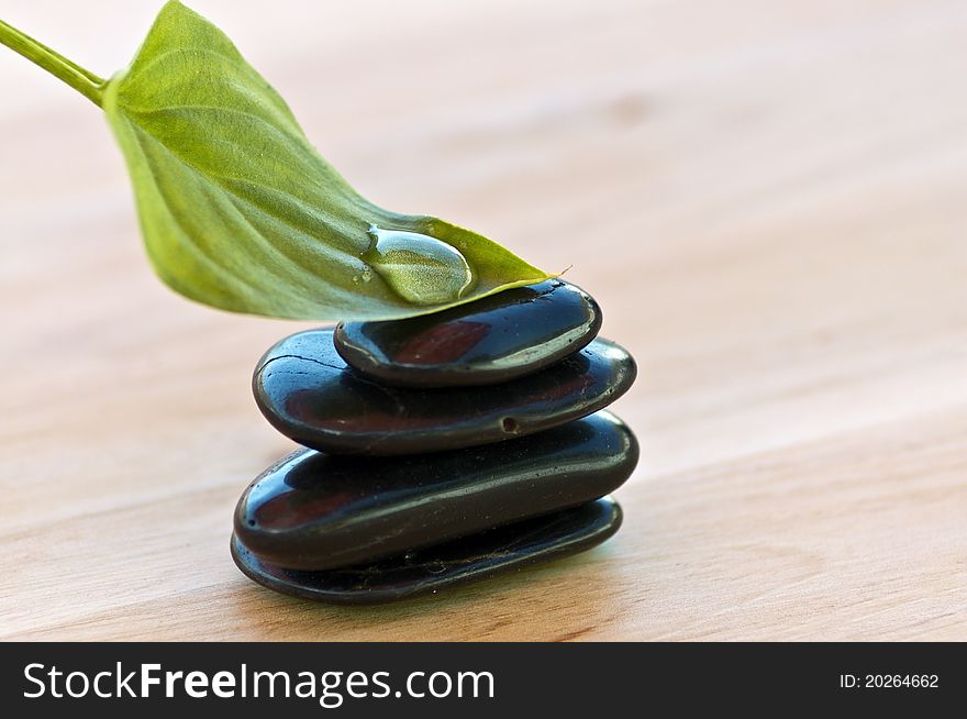 Zen stones with leaf and drop water in wood background