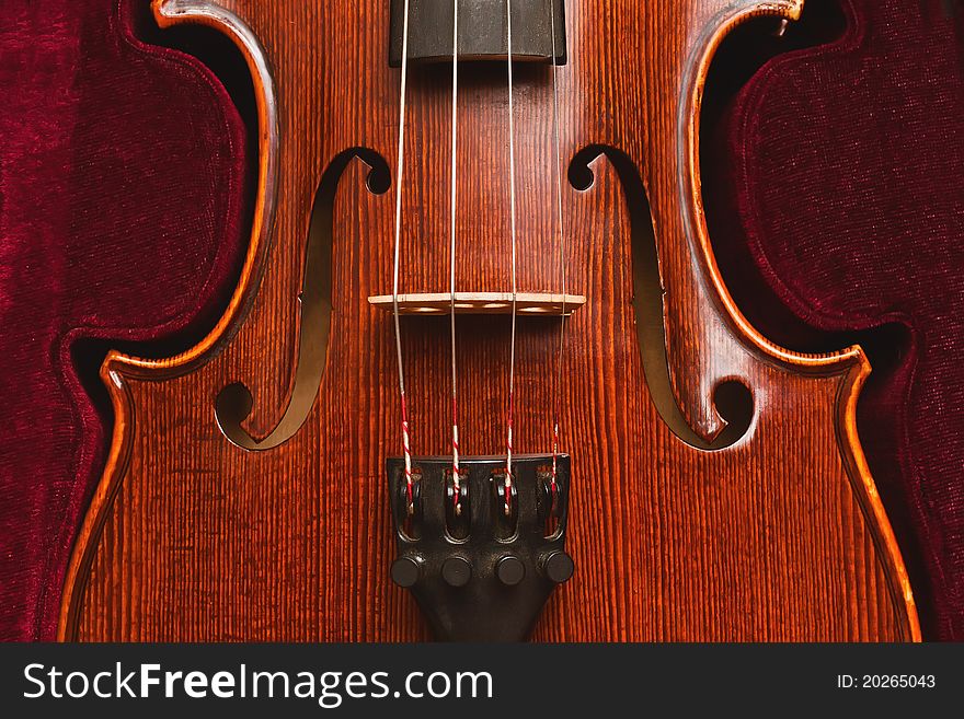 Close up of violin with dark red background. Close up of violin with dark red background
