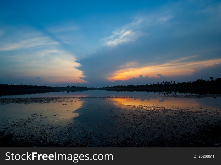 Cloudscape of sunset with blue sky and lake.